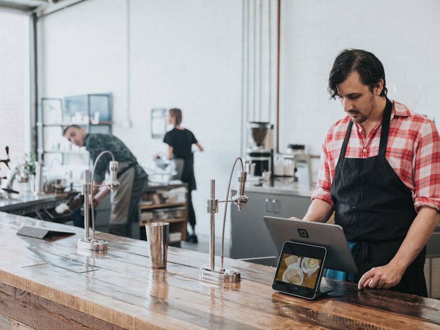 Kafe xodimi pult ortida planshet bilan ishlamoqda